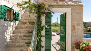 A stone staircase with green shutters leading to a doorway. - Villa Brač Stone with Swimming Pool (Bol)