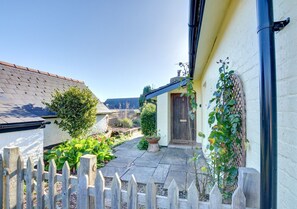 Stroll through a serene garden surrounded by lush greenery and a traditional door.