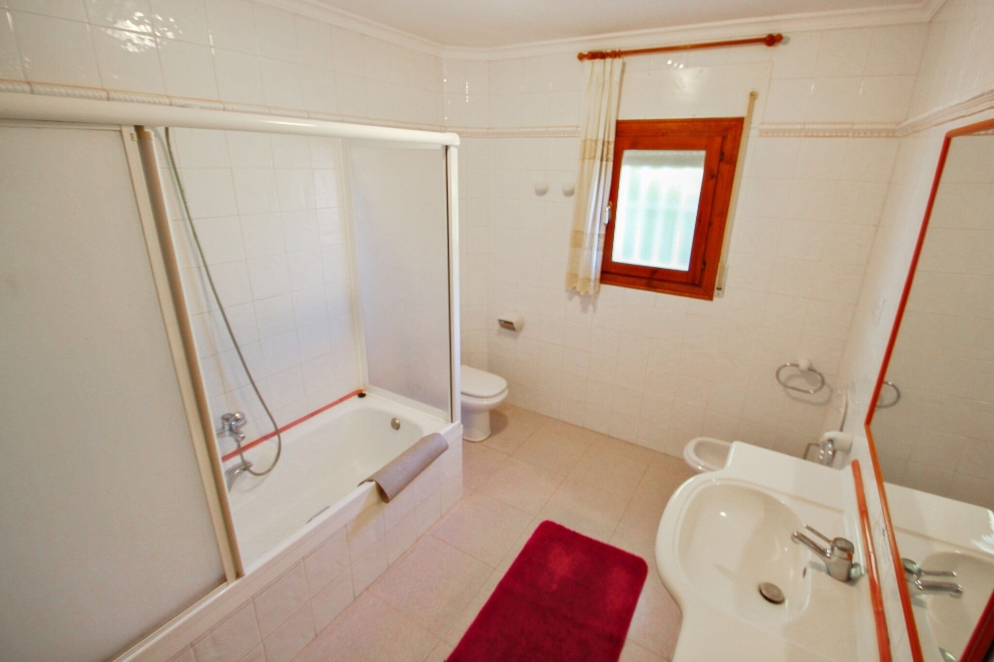A bathroom with a bathtub, toilet, and sink.