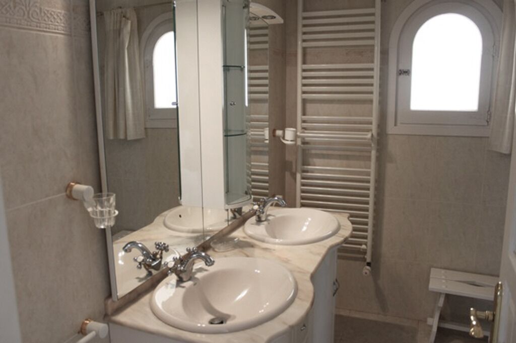 A bathroom with two sinks, a large mirror, and a towel rack.