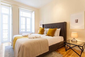 Ein Schlafzimmer mit Bett, Nachttisch und Fenster.
