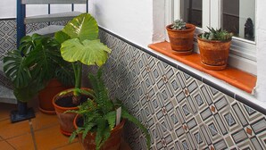 A spiral staircase, potted plants, a window with a view, and patterned tiles.