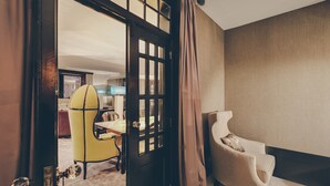 A room with a large window, a door with curtains, a yellow chair, and a beige armchair. - Master Deco Gem in Bica (Lisboa)