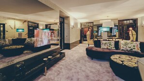 A spacious living room with a large flat-screen TV, comfortable seating, and a carpeted floor. - Master Deco Gem in Bica (Lisboa)