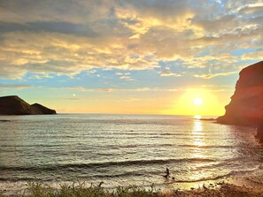 A sunset over a calm sea with cliffs on either side. - Self Catering Cottage, Crackington Haven, Bude, Cornwall, Peace awaits you. (Bude)