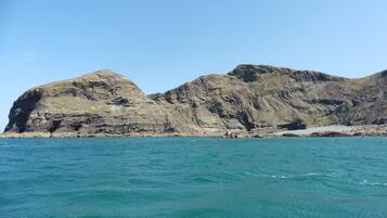 A coastal landscape with rocky cliffs and a clear blue sea.