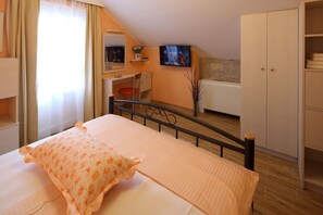 Ein Schlafzimmer mit einem Bett, einem Schreibtisch, einem Fernseher und einem Kleiderschrank.