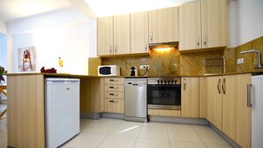 A modern kitchen with wooden cabinets, a built-in microwave, a dishwasher, and an oven. - Spacious apartment in the Center of Palma, Ideal for Families. (Palma)