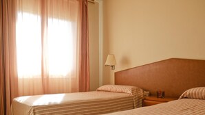 A hotel room with two beds, a nightstand, a lamp, and a window with curtains. - Apartments with terrace and communal pool. Ref. Tropik-24 (Estartit)