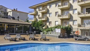 A swimming pool with lounge chairs, a bar area, and a building with balconies. - Apartments with terrace and communal pool. Ref. Tropik-24 (Estartit)