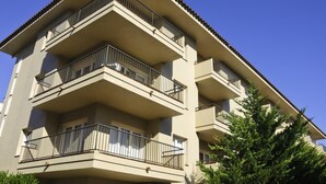 A multi-story building with balconies, a tiled roof, and a clear blue sky. - Apartments with terrace and communal pool. Ref. Tropik-24 (Estartit)