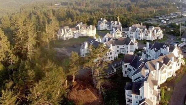 A residential area with multiple houses, surrounded by trees and a hilly landscape. - Schooner Landing (Newport)