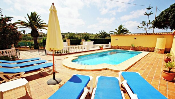 A swimming pool with blue lounge chairs and a yellow umbrella. - Finca Vicente - charming, Spanish finca style holiday villa in Teulada (Teulada)