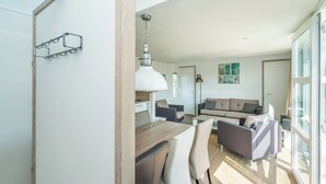 Een moderne woonruimte met een eethoek, een bank en een groot raam.