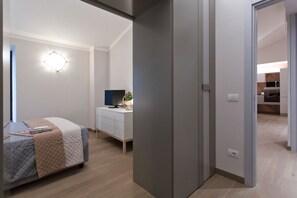 A modern bedroom with a bed, bedside table, and a wall-mounted light fixture. - IL TOLOMEI - new apartment in the middle of the main street (Siena)