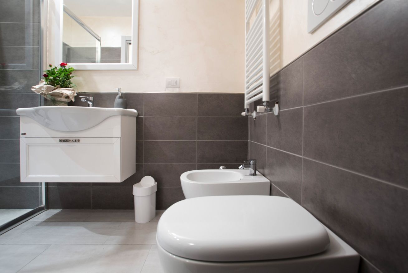 Un bagno moderno con il water, un bidet e un lavandino.