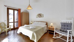 A bedroom with a bed, a chair, a wardrobe, a lamp, and a painting on the wall. - Wonderful private villa for 8 people with private pool, WIFI, A/C and TV (Marina Di Ragusa)