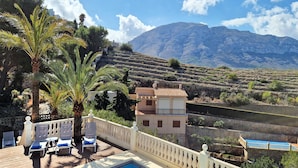 A terrace with lounge chairs, a pool, and a view of terraced vineyards and mountains. - Doble Diez - Denia, Costa Blanca (Denia)