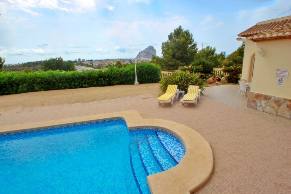 Ein Swimmingpool mit Liegestühlen und Bergblick.