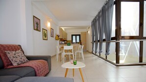 Una sala de estar con un sofá, una mesa de centro y un comedor con sillas y una mesa.