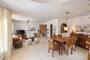 A spacious living area with a dining table, sofas, and a television. - Chrisuli - well furnished villa with panoramic views in Moraira (Benimeit)