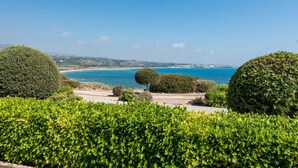 A landscaped garden with neatly trimmed hedges and a view of the sea. - Villa Tequila Sunrise by Ezoria Villas (Coral Bay)