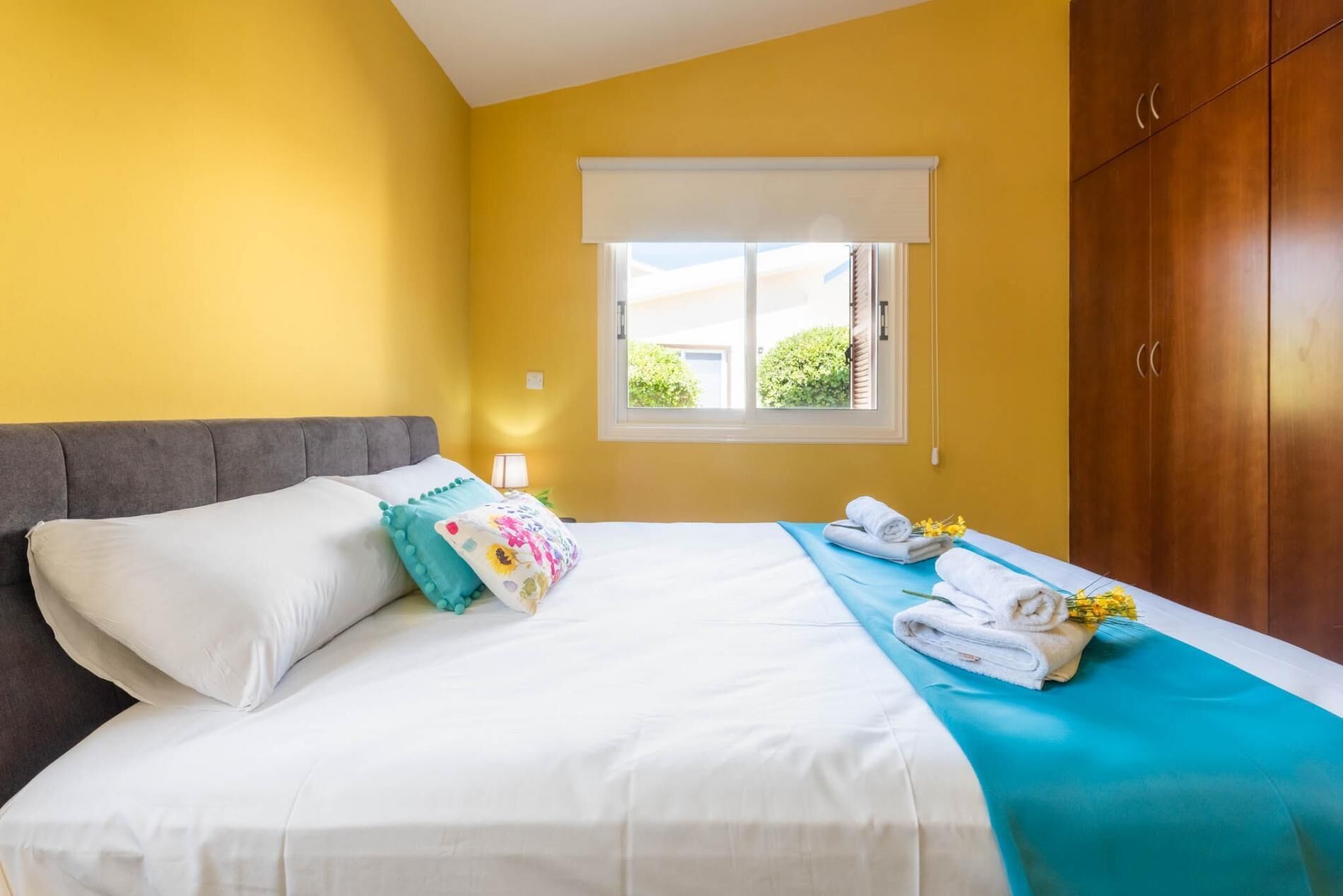 Een hotelkamer met een bed, een raam met uitzicht en een kledingkast.