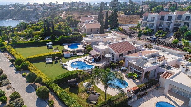 A residential area with multiple houses, a swimming pool, and a well-maintained garden. - Villa Tequila Sunrise by Ezoria Villas (Coral Bay)