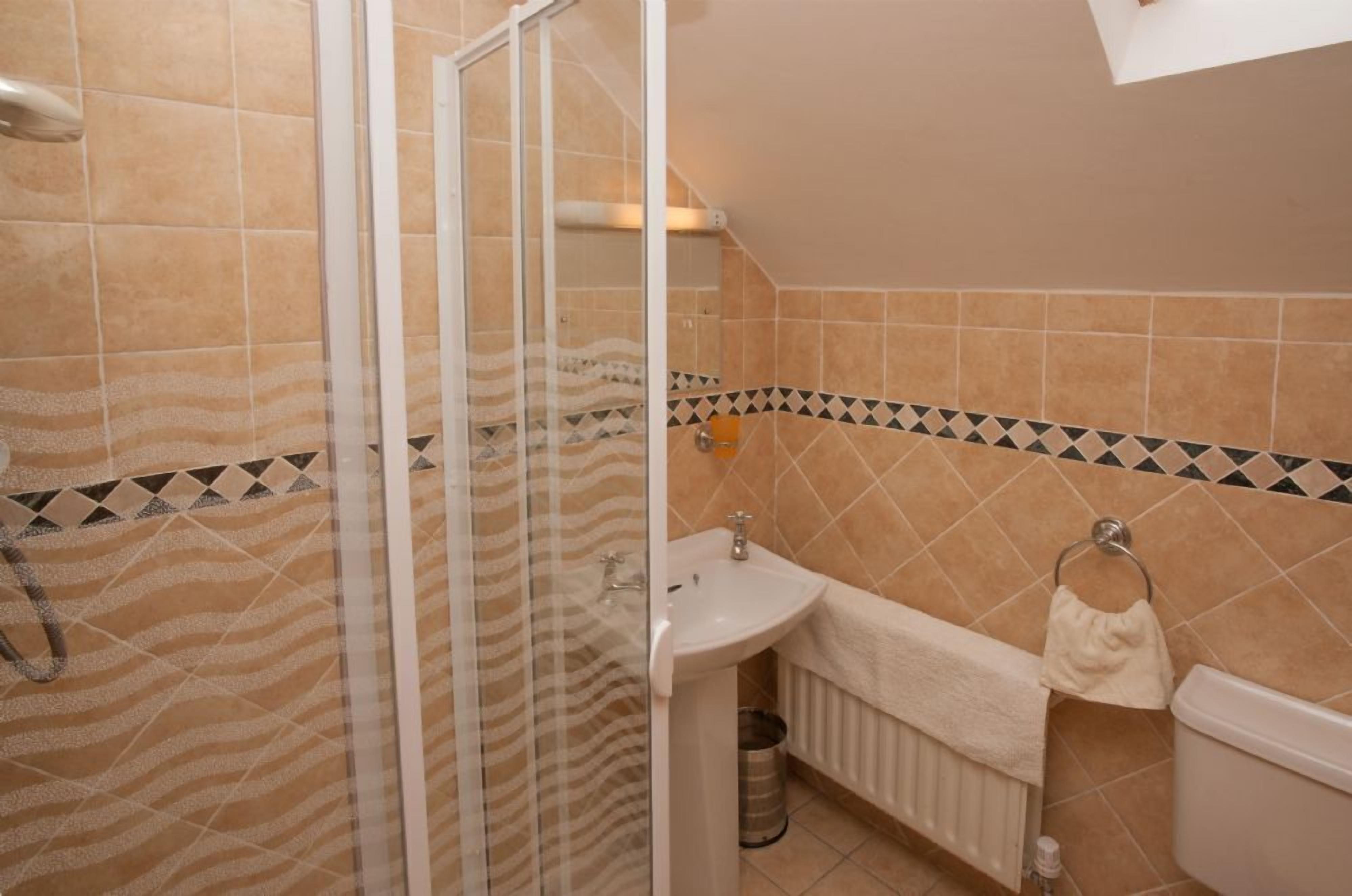 Une salle de bain avec une douche, un lavabo et des toilettes.