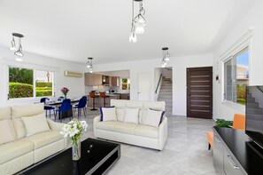 Ein modernes Wohnzimmer mit Sofa, Couchtisch und Essbereich.