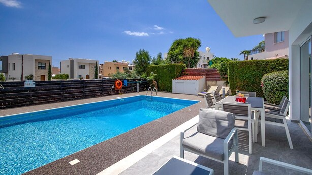 A rooftop swimming pool with a view of surrounding buildings, a lifebuoy, and outdoor seating. - Villa Roker by Ezoria Villas (Coral Bay)