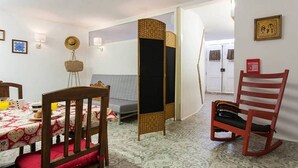 A cozy room with a dining table, chairs, a sofa, and a bed. - JOIVY Calm 1-bed flat (Lisbon)