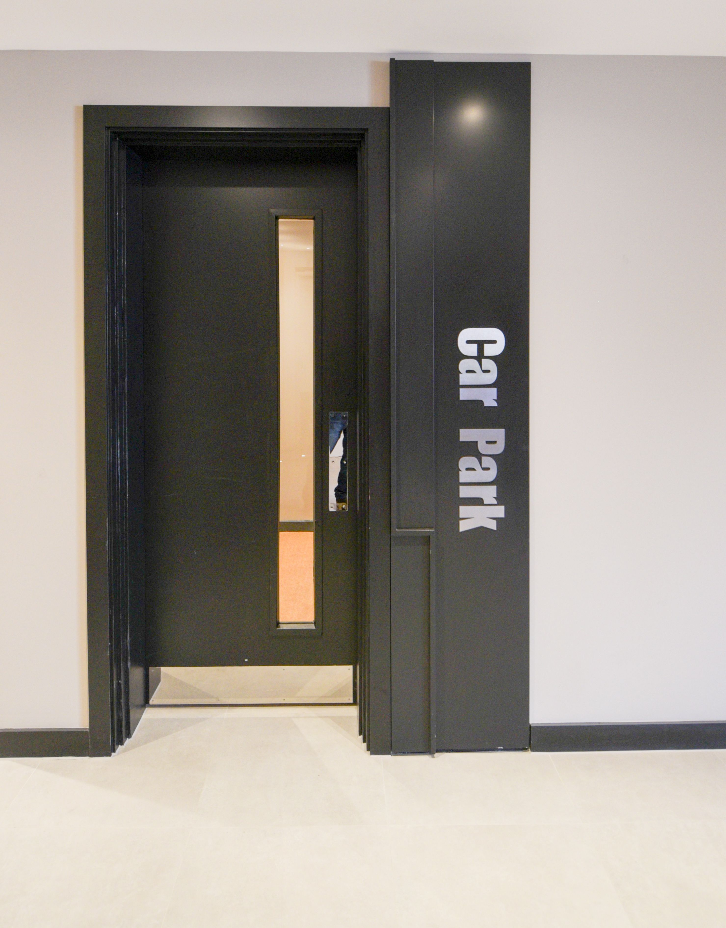 A modern hallway with a door labeled "Car Park".