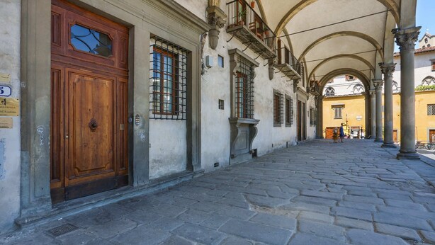 A cobblestone street with a wooden door and windows with metal bars. - Belle Arti' Stunning Apartment (Florence)