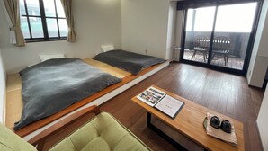 A room with two beds, a table with a menu, and a view of the outside balcony. - Spa Lodge Redwood Inn (Takayama)