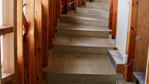 A wooden staircase with carpeted steps leading to a door at the top. - Spa Lodge Redwood Inn (Takayama)