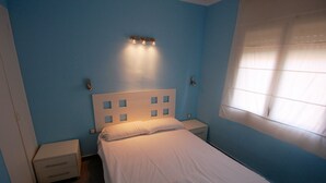 A bedroom with a single bed, a nightstand, a drawer unit, and a window with blinds. - Mare Nostrum 2D 324 - Close to the beach, modern (Torroella de Montgri)