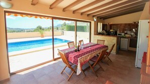 A dining area with a table set for four, overlooking a swimming pool. - Santa Ana - pretty holiday property with garden and private pool in Benissa (Benissa)