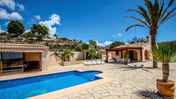 A swimming pool with a stone patio, lounge chairs, and a palm tree. - Santa Ana - pretty holiday property with garden and private pool in Benissa (Benissa)