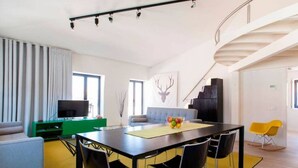 Una sala de estar moderna con comedor, una escalera y una televisión.