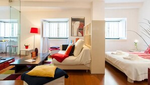 Una moderna camera d'albergo con un divano, un letto, una scrivania e una libreria.