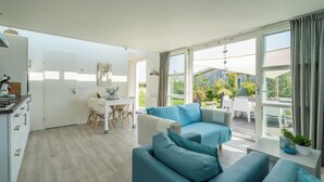 Un salon moderne comprenant un canapé, une table à manger et un coin cuisine.
