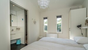 Camera da letto con un letto grande, un armadio, un comodino e una finestra.