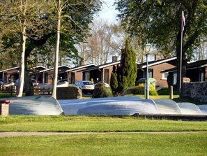 A row of single-story houses with a grassy lawn in front.