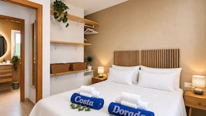 Ein Hotelzimmer mit einem Bett, Nachttischen, einem Spiegel, einem Deckenventilator und einer Pflanze.