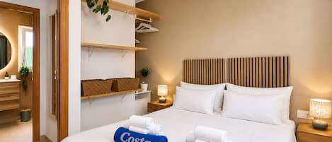 A hotel room with a bed, bedside tables, a mirror, a ceiling fan, and a plant.