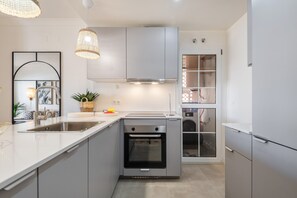 A modern kitchen with a built-in oven, a sink, and a countertop.