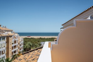 A view of a beach from a balcony with a clear sky.