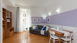 Un salon confortable avec un canapé, une petite table et une bibliothèque.