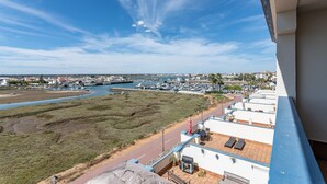 Blick aufs Meer vom Balkon mit Blick auf einen Yachthafen, einen Fluss und eine Stadt am Horizont.